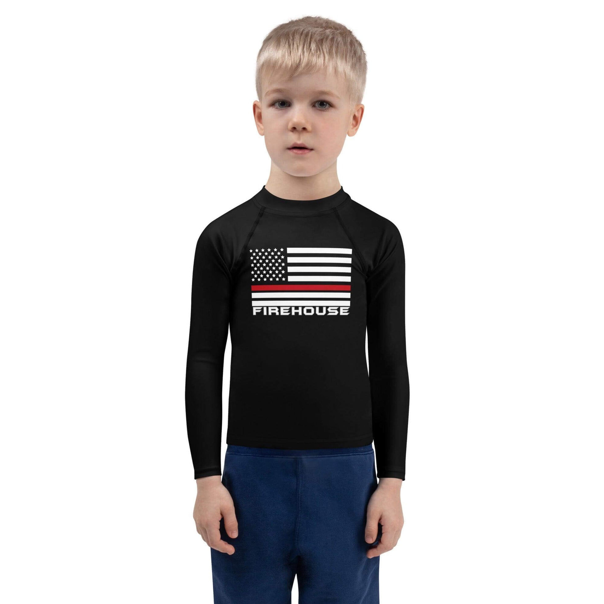 Kid wearing a black long-sleeve rash guard with a firefighter-themed graphic, perfect for sun protection and beach fun.